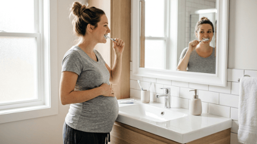 Pregnant woman brushing her teeth