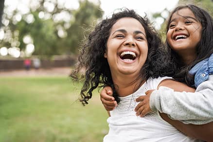 Smiles Art Dentistry
| Mother and daughter laughing outdoors on a sunny day.